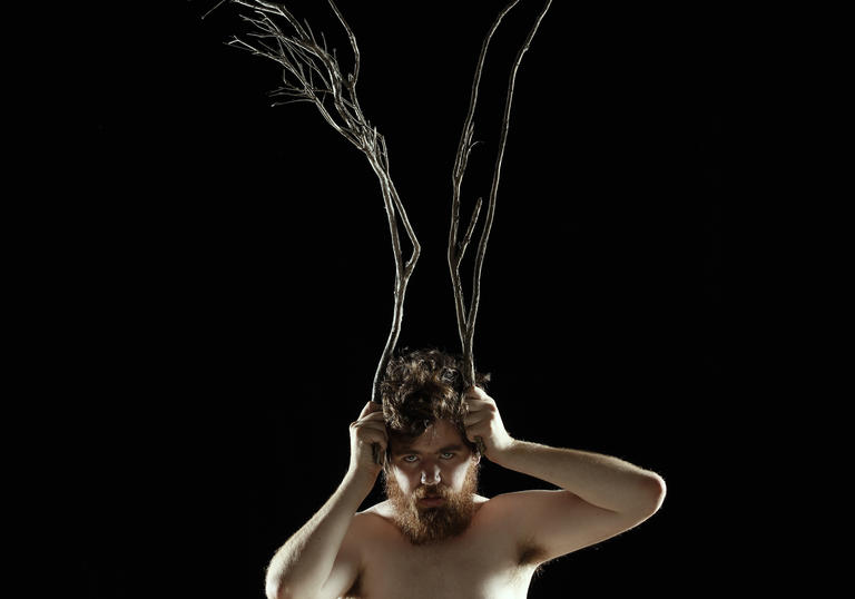 Photo of man with wooden twigs on his head