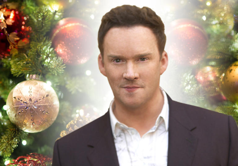Image of Russell Watson against a backdrop of Christmas decorations