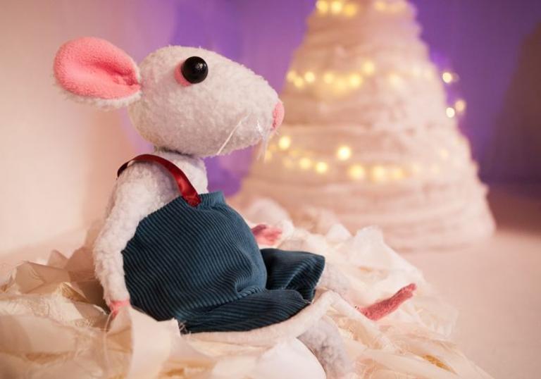 A photo of a mouse puppet against a snowy background