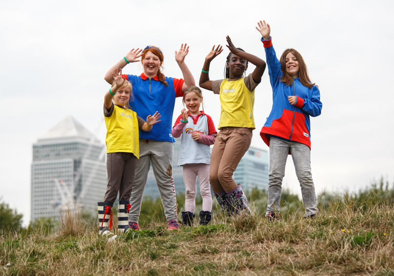 group of girls on a grassy hill, jumping