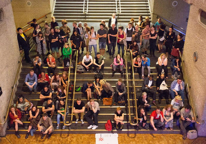 Photo of visitors watching a performance on the stairs