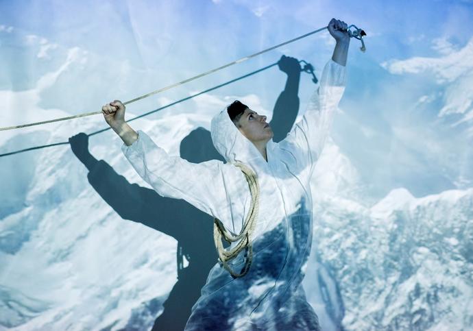 Image of person in front of a projection of snow covered mountains