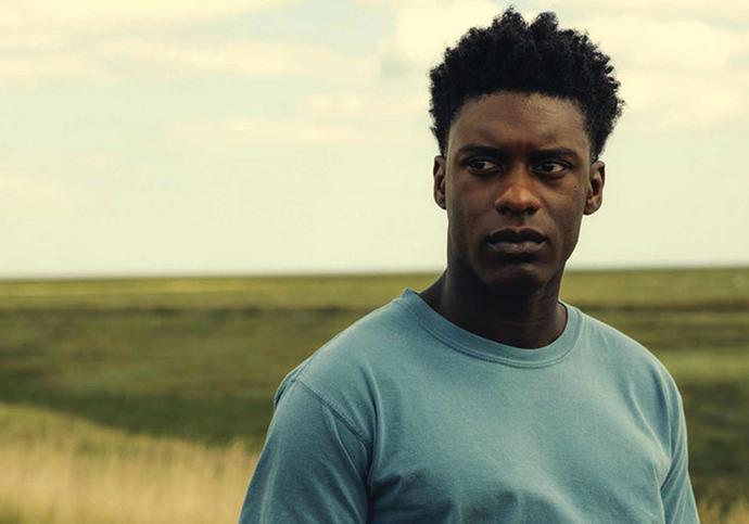 Young man stands in field