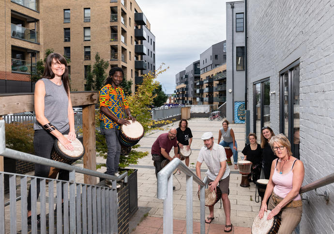 A group of people stand on stairs playing drums