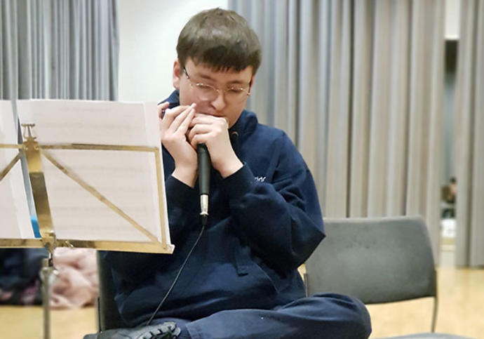 Young man in studio playing harmonica