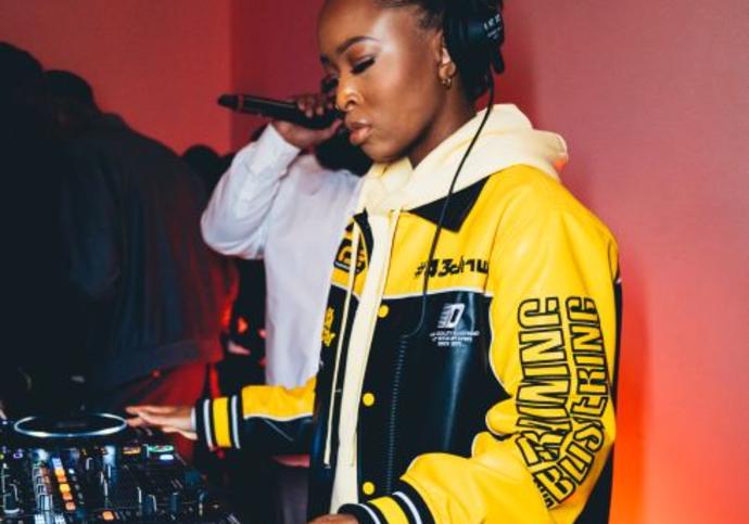 black female djing in a black and yellow jacket