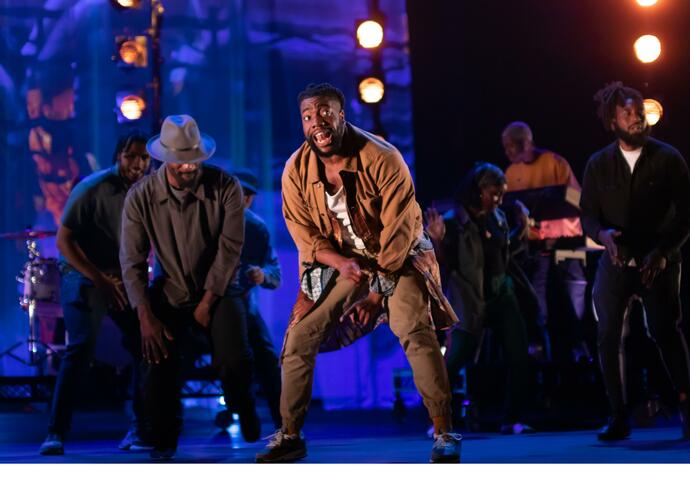 Group of dancers on a stage with blue background and lights