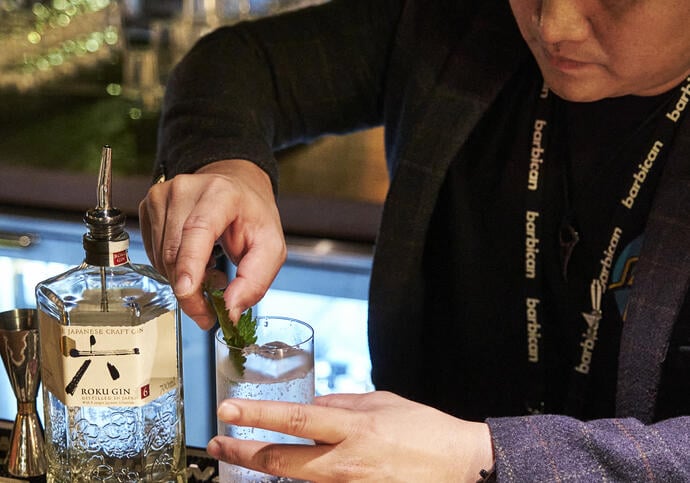 A barperson making a gin cocktail at the Members' Lounge bar.