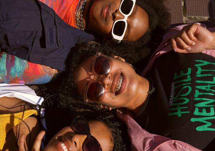 3 girls lying down with sunglasses on smiling