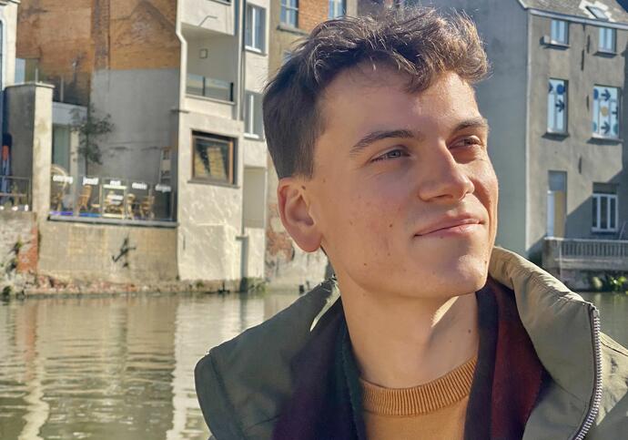 Image of Gabriele looking into the distance, standing in front of houses