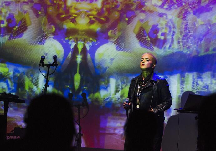 Image of artist Reeta singng. They are standing