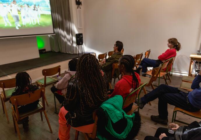 People sat down on chairs watching film