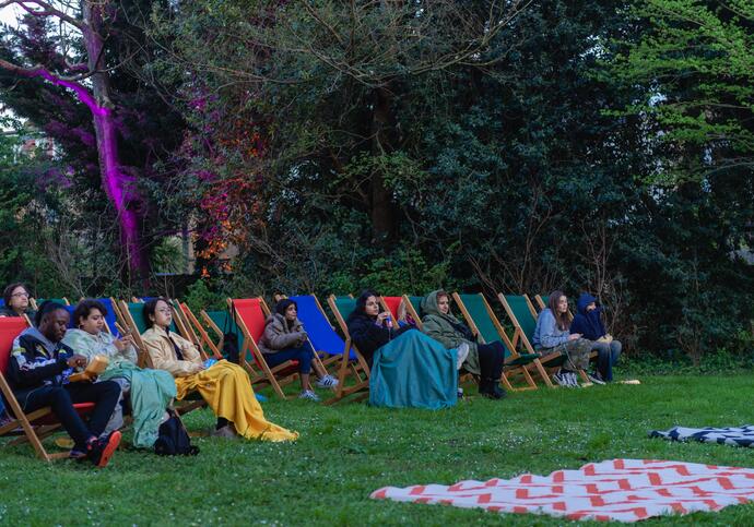 People sat on chairs outside for outdoor cinema