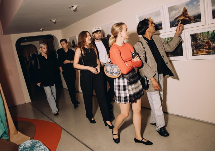 Image of group of people walking through an art exhibition