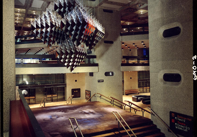 A photograph of the Barbican's original foyers in 1982, with a large geometric sculpture suspended from the ceiling
