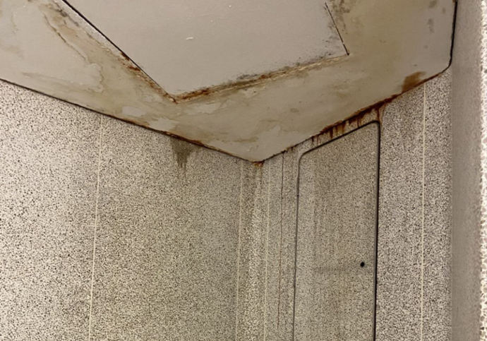A close up of the effect of leaks from the ceiling in the toilets