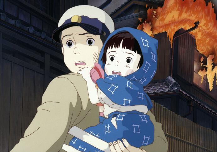 A young girl sits on the back of a young boy as they run away from a flaming landscape.