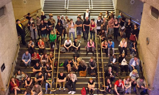 Photo of visitors watching a performance on the stairs