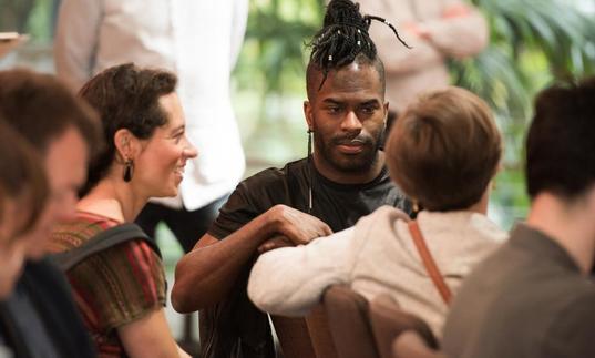 Photo of man with dreadlocks in the crowd at a symposium