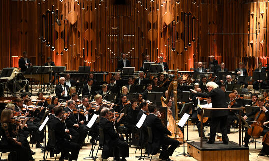 Photo of Sir Simon Rattle conducting the London Symphony Orchestra in the Barbican Hall