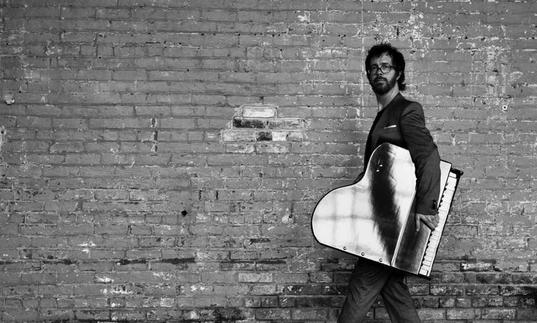 A giant Ben Folds holds a grand piano under his arm or a normal sized Ben Folds holds a miniature piano under his arm - who knows? Either way it's a lot of fun ! 