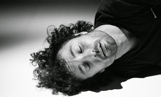 Man rests head on floor in black and white