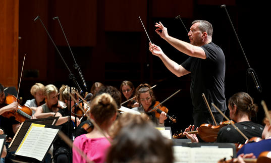 Thomas Ades conducting on stage 2017