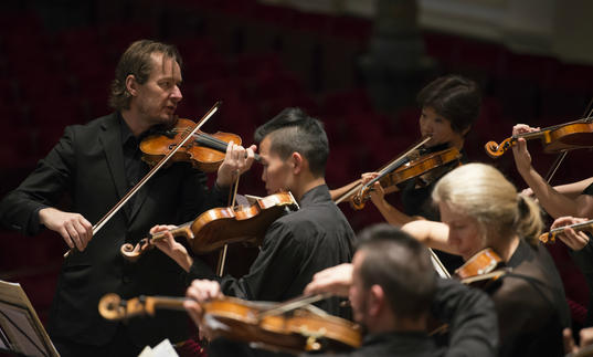 ACO and Tognetti on stage playing 