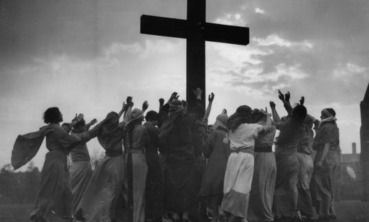 Group of people surrounding a cross