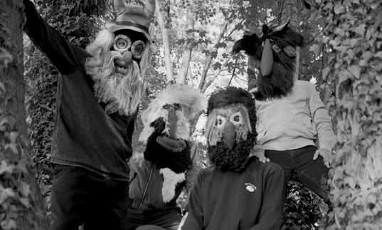 Pantha Du Prince and his collaborators in a tree wearing masks