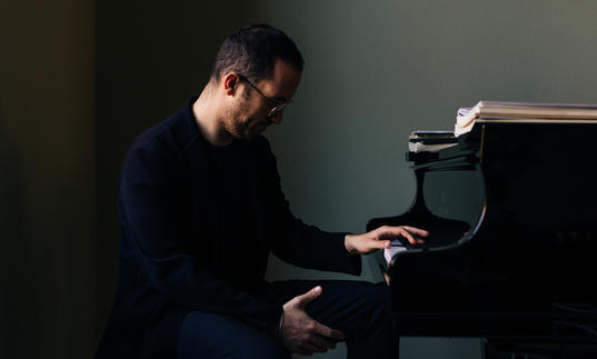Igor Levit sitting at piano