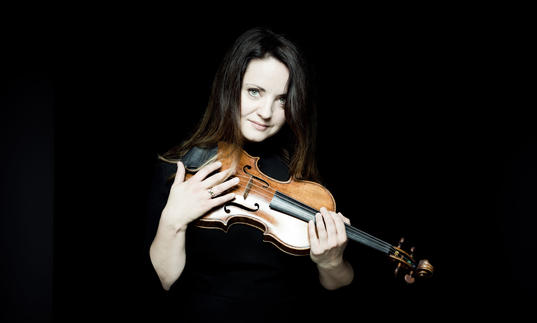 Baiba Skride with violin dark background