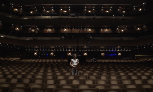 Woman playing violin in Barbican theatre