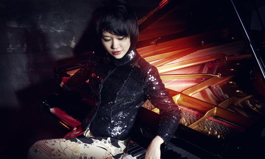 Yuja Wang sitting backwards at a piano