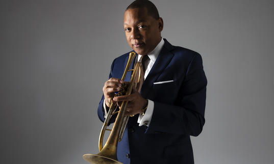 Wynton Marsalis wearing a suit, holdin his trumpet