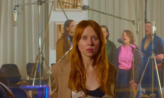 Holly Herndon in front of a choir recording