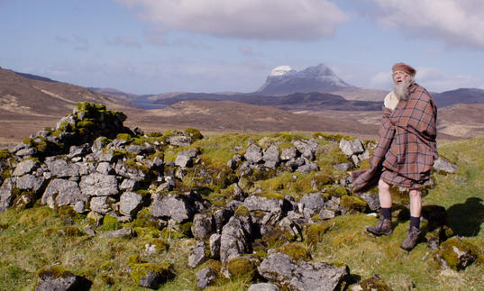 Man in kilt standing on a hill