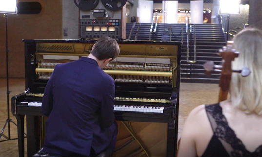 photo of erland cooper in front of a piano in the barbican foyer