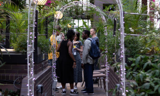 A group of people standing under an arch in conservatory