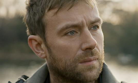 A headshot of Damon Albarn looking to the distance