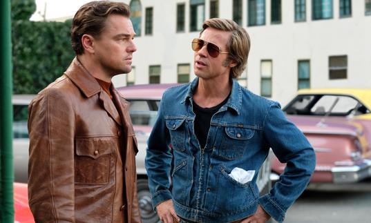 Leo Dicaprio and Brad Pitt talking together in the street