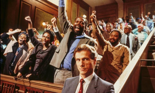 a group of black people standing up in court with their fists raised