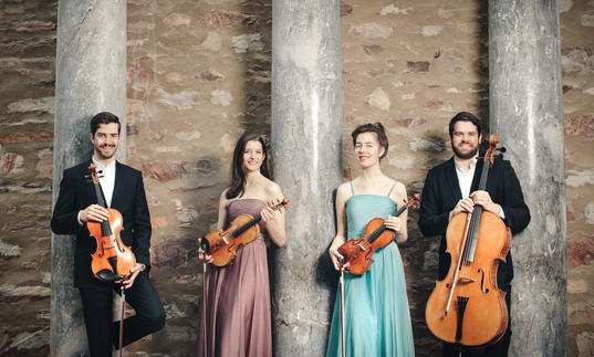 The Aris Quartet posing with their instruments 