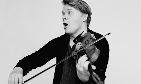 An image of Pekka joyfully playing his violin 