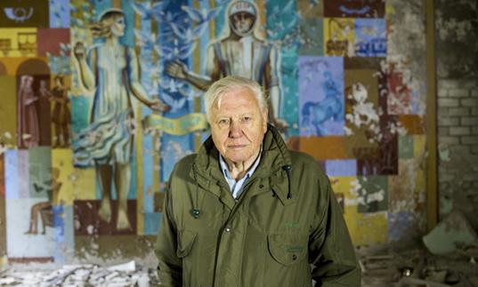 David Attenborough in front of a painted mural