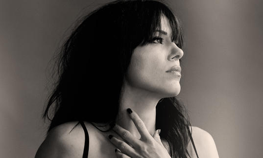 Imelda May looking to the left and holding her hand up to her neck