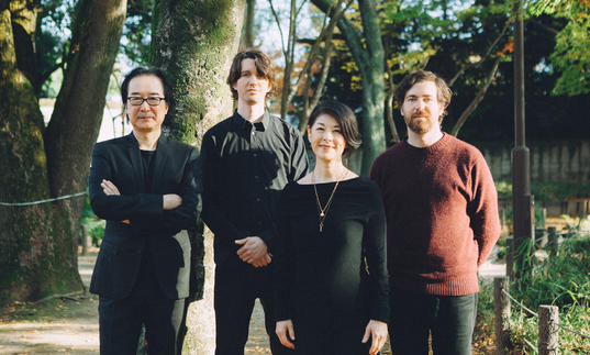 Spencer Doran and Ryan Carlile (Visible Cloaks) with Yoshio Ojima and Satsuki Shibano standing in a park