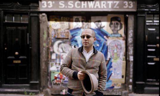 Mahan Esfahani in front of a graffiti wall