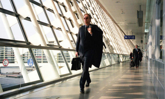 Man walking down a glass corridor