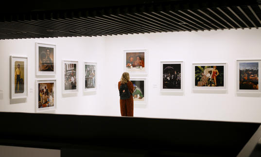 Woman looking at a wall filled with photographs